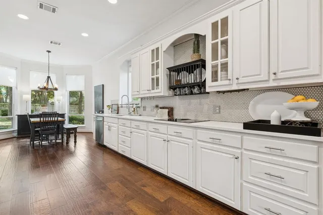 a kitchen with white cabinets and sink