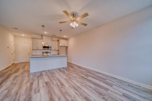 a kitchen with kitchen island white cabinets and stainless steel appliances