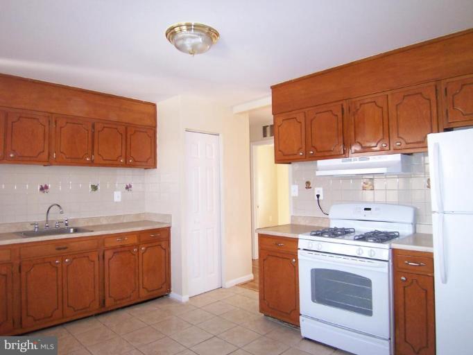 8110 Phelps Place District Heights, MD 20747 - Photo 3 of 13 a kitchen with a sink stove and cabinets