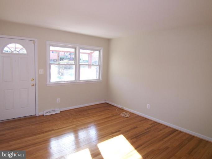 8110 Phelps Place District Heights, MD 20747 - Photo 4 of 13 an empty room with wooden floor and windows