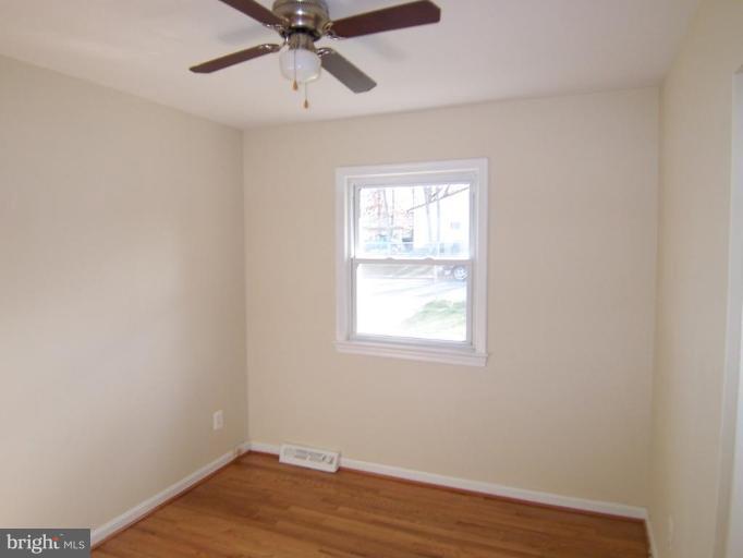 8110 Phelps Place District Heights, MD 20747 - Photo 5 of 13 an empty room with wooden floor fan and windows