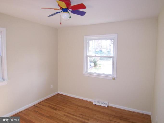 8110 Phelps Place District Heights, MD 20747 - Photo 6 of 13 an empty room with wooden floor fan and windows