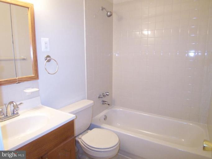 8110 Phelps Place District Heights, MD 20747 - Photo 7 of 13 a bathroom with a granite countertop toilet a sink and a bathtub