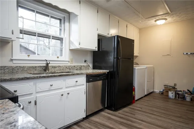 a kitchen with granite countertop a stove oven and white cabinets