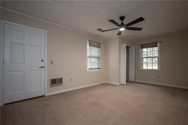 an empty room with closet and windows