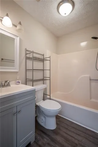 a bathroom with a granite countertop toilet sink and mirror