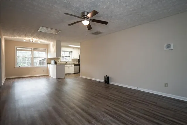 a view of a kitchen with a dishwasher a kitchen island hardwood floor and a window