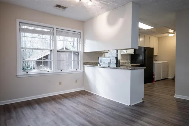 a kitchen with granite countertop white cabinets and a stainless steel appliances