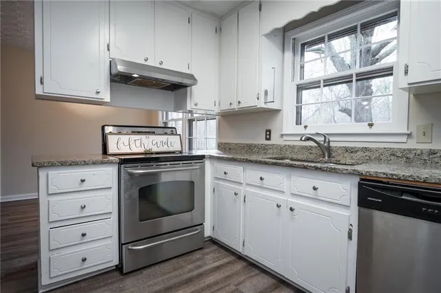 a kitchen with granite countertop a refrigerator and a sink