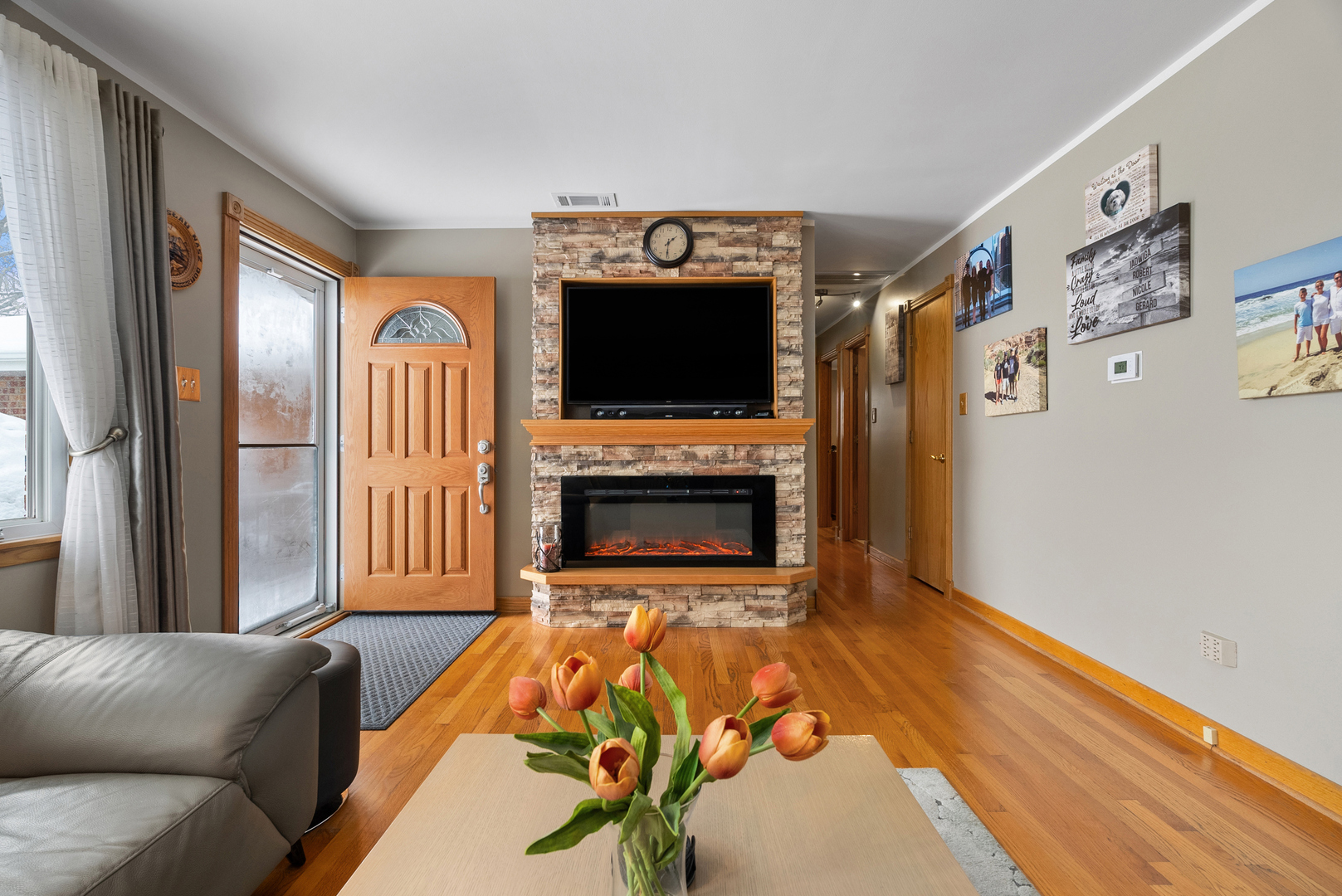 8232 Ferdinand Avenue Bridgeview, IL 60455 - Photo 3 of 35 a living room with furniture a flat screen tv and a fireplace