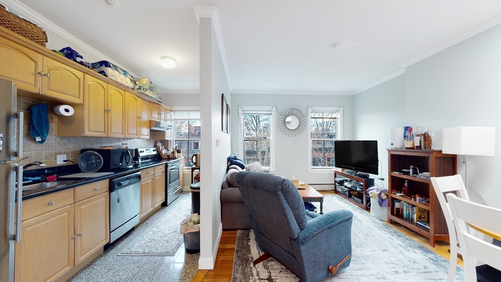 a living room with furniture a flat screen tv and a window