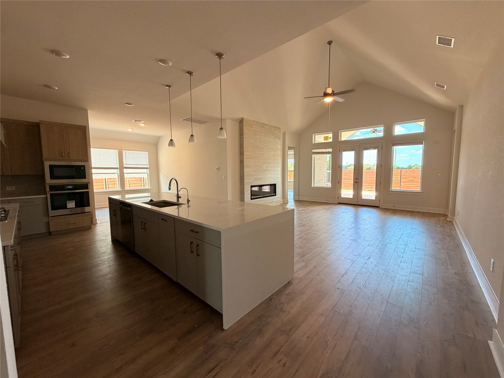 2212 Tobiano Trace Georgetown, TX 78633 - Photo 3 of 33 A spacious, open-concept living area features a modern kitchen island and soaring vaulted ceilings.