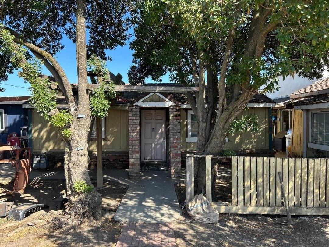 a front view of a house with a tree