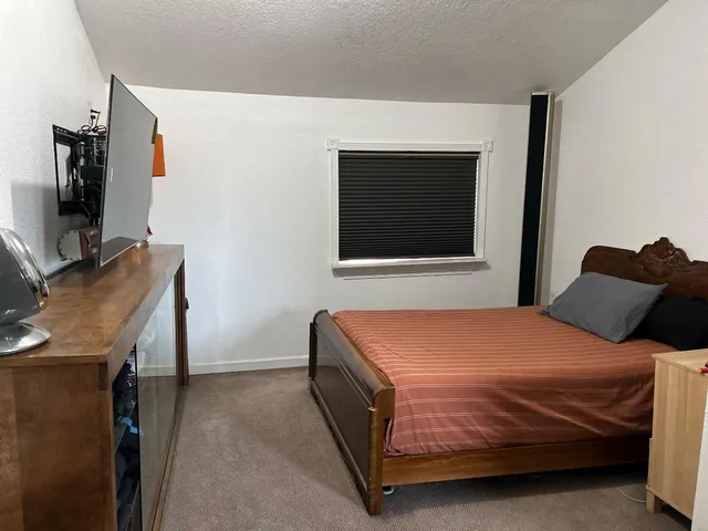 a bedroom with a bed and a flat screen tv