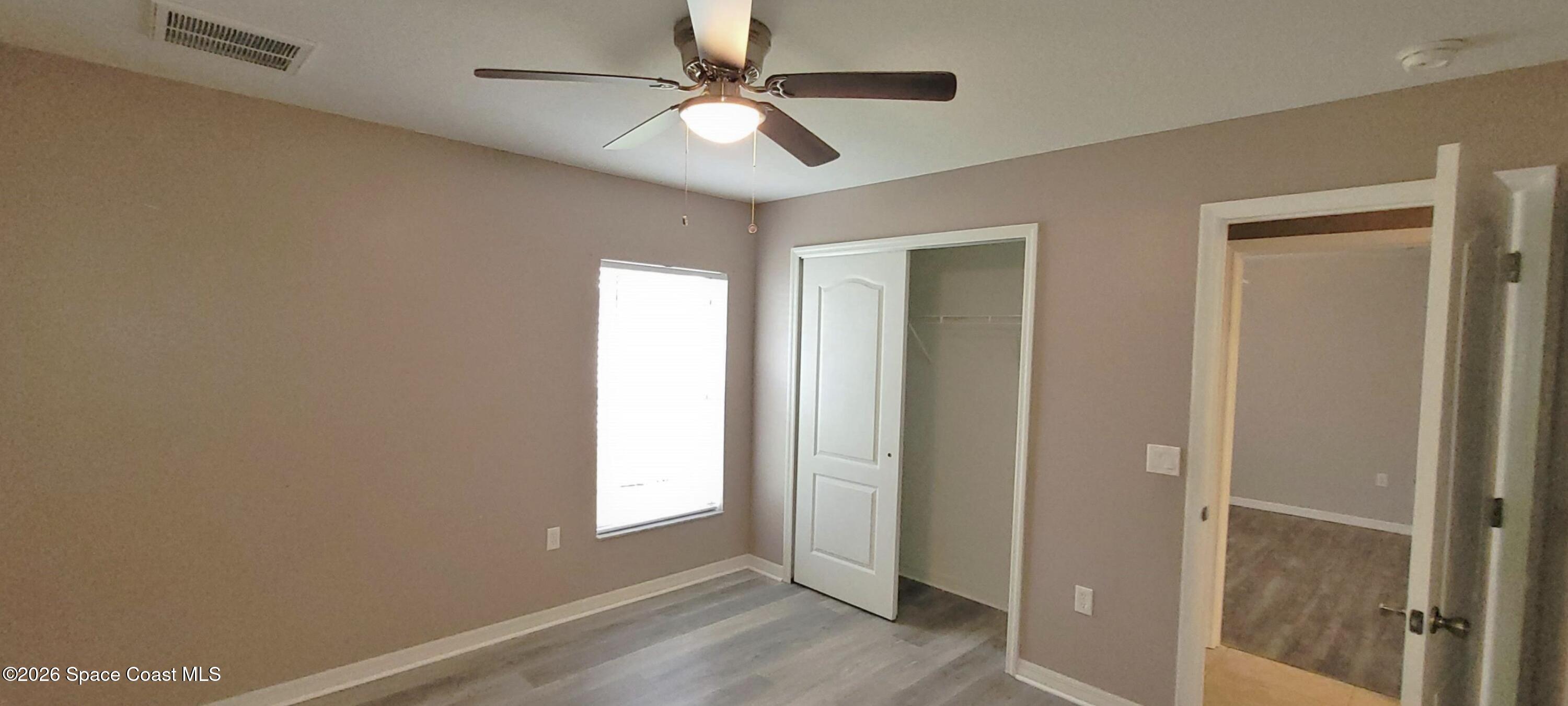 2033 Gloria Circle Palm Bay, FL 32905 - Photo 13 of 28 a view of empty room with wooden floor and fan