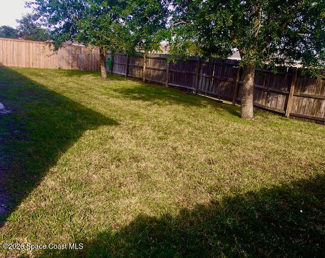2033 Gloria Circle Palm Bay, FL 32905 - Photo 3 of 28 a view of a backyard with a small cabin and wooden fence