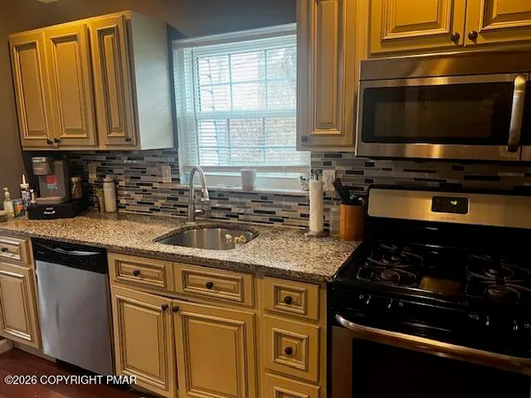 a kitchen with stainless steel appliances granite countertop a stove and a microwave