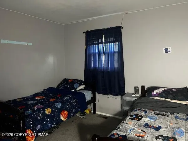 a bedroom with a bed window and dresser