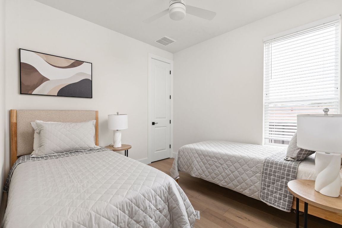 1402 Summit Street, Unit A Austin, TX 78741 - Photo 11 of 30 a bedroom with a bed and wooden floor