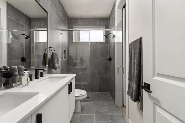 a bathroom with a double vanity sink toilet and shower