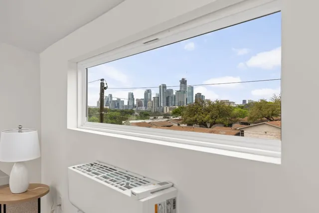 a view of a room that has a bed and a dresser in it