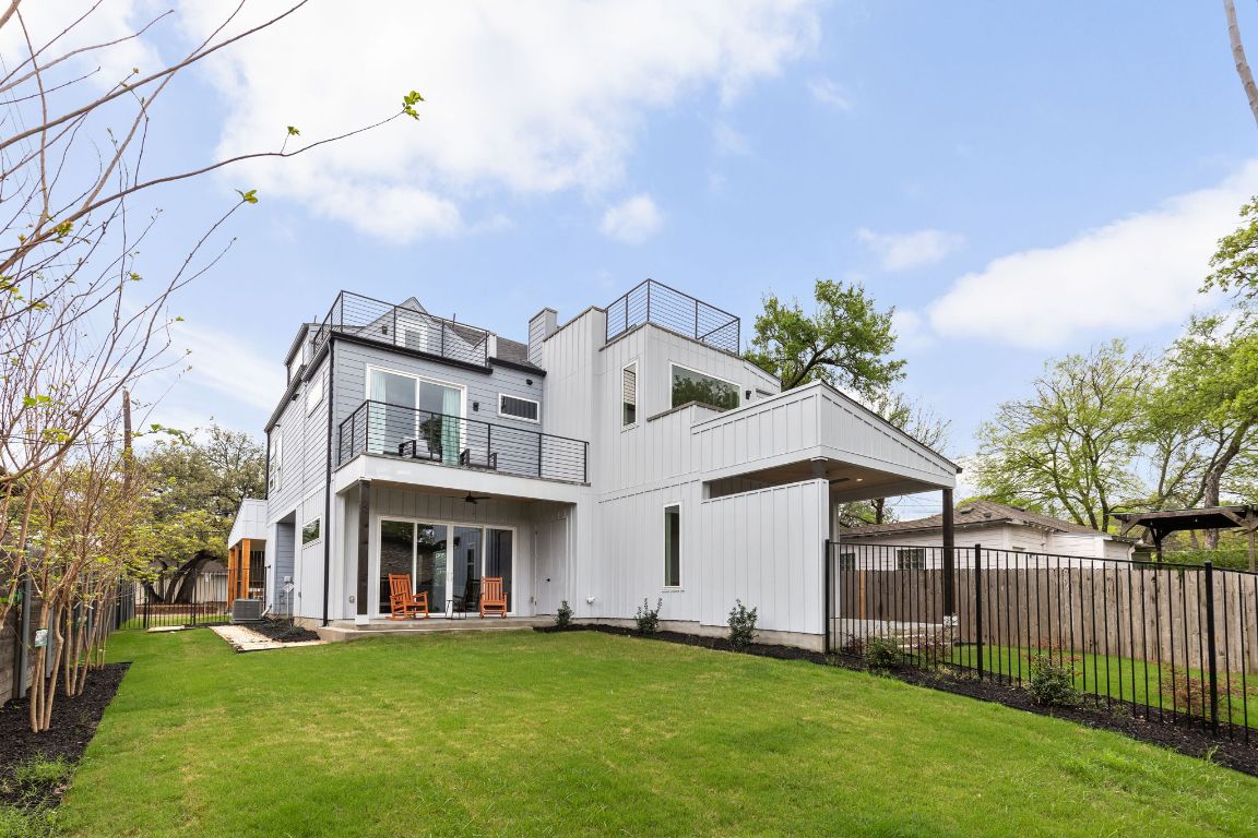 1402 Summit Street, Unit A Austin, TX 78741 - Photo 28 of 30 a view of a white house with a big yard and large trees