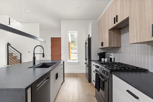 a kitchen with stainless steel appliances granite countertop a refrigerator a sink a stove a microwave and island