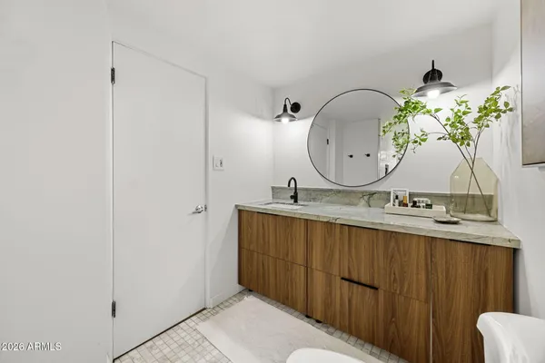 a bathroom with a granite countertop sink a mirror and vanity