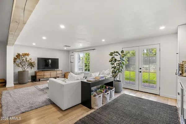 a living room with furniture a flat screen tv and a floor to ceiling window