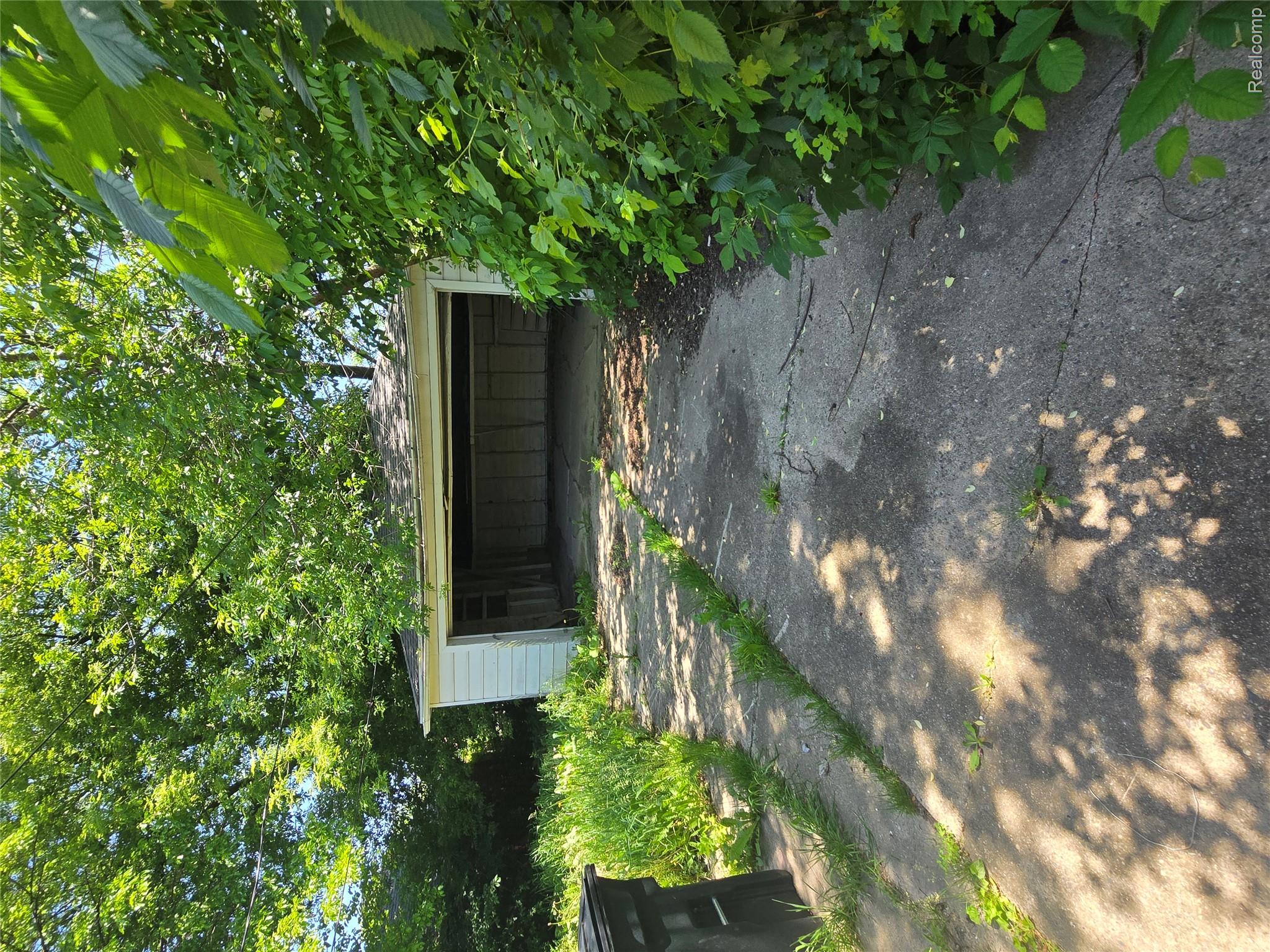 10342 Roxbury Street Detroit, MI 48224 - Photo 4 of 30 Detached garage featuring a single bay opening, white siding, and a concrete driveway
