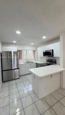 a kitchen with stainless steel appliances a refrigerator sink and cabinets