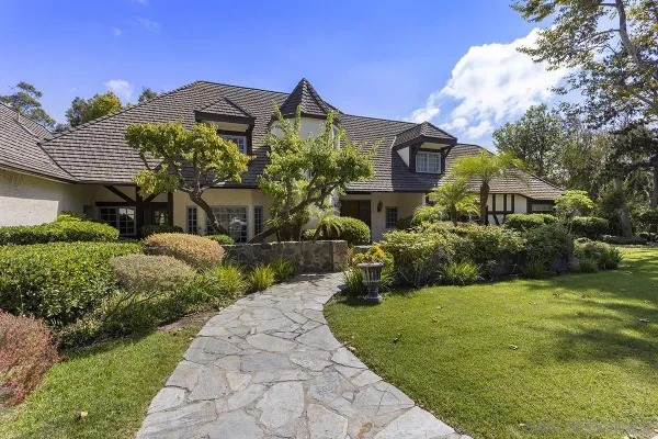 a view of a house with a large window and plants