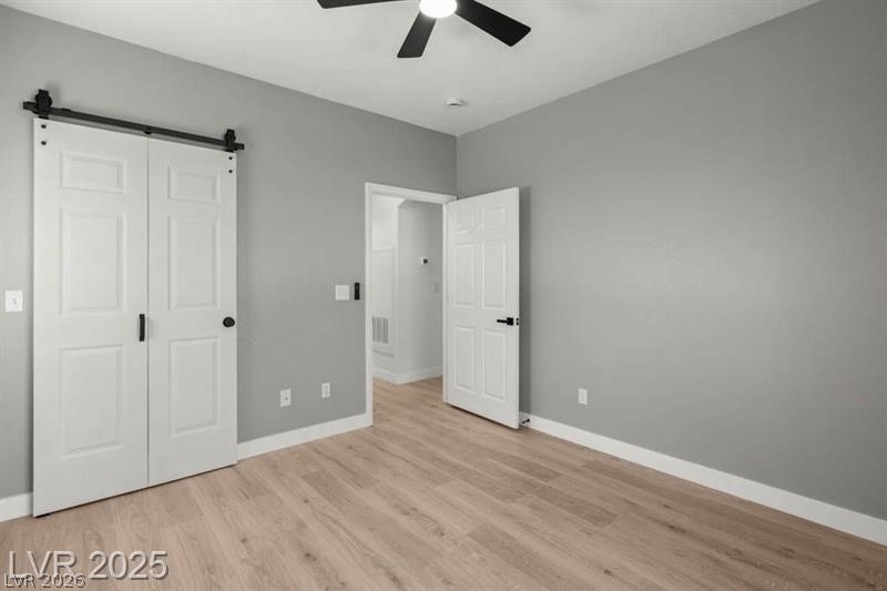 3320 South Fort Apache Road, Unit 125 Las Vegas, NV 89117 - Photo 10 of 26 Luminous room featuring a sleek ceiling fan and light-toned hardwood flooring.