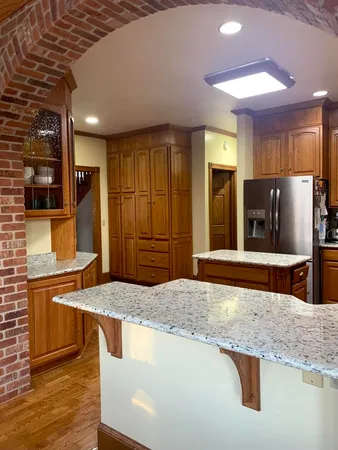 a kitchen with stainless steel appliances granite countertop a sink and a refrigerator