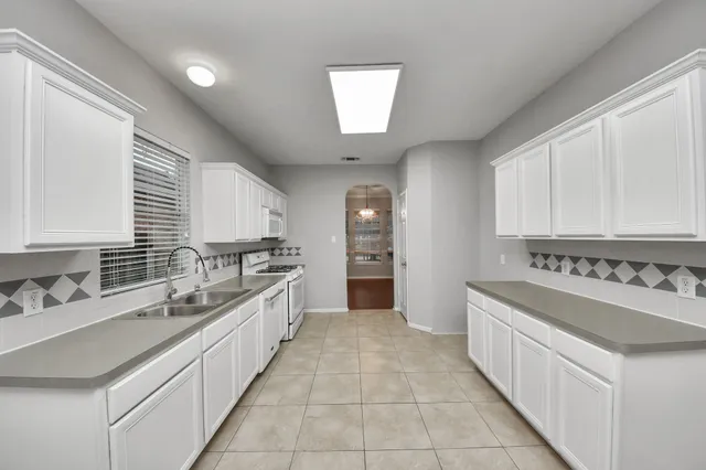 a large white kitchen with a large window