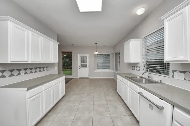 a large white kitchen with a large window