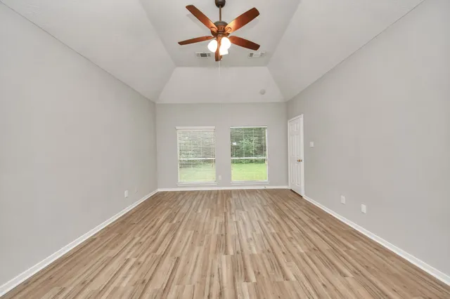 wooden floor in an empty room with a window