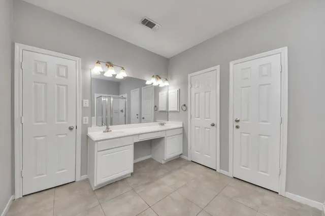 a large bathroom with a sink and a mirror