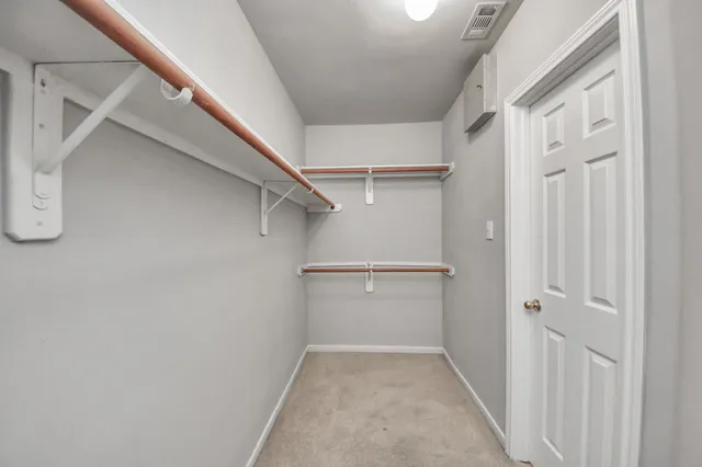 a view of walk in closet with empty racks