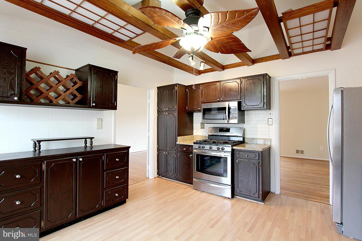 12917 Layhill Road Silver Spring, MD 20906 - Photo 11 of 30 a kitchen with stainless steel appliances granite countertop a stove and a refrigerator