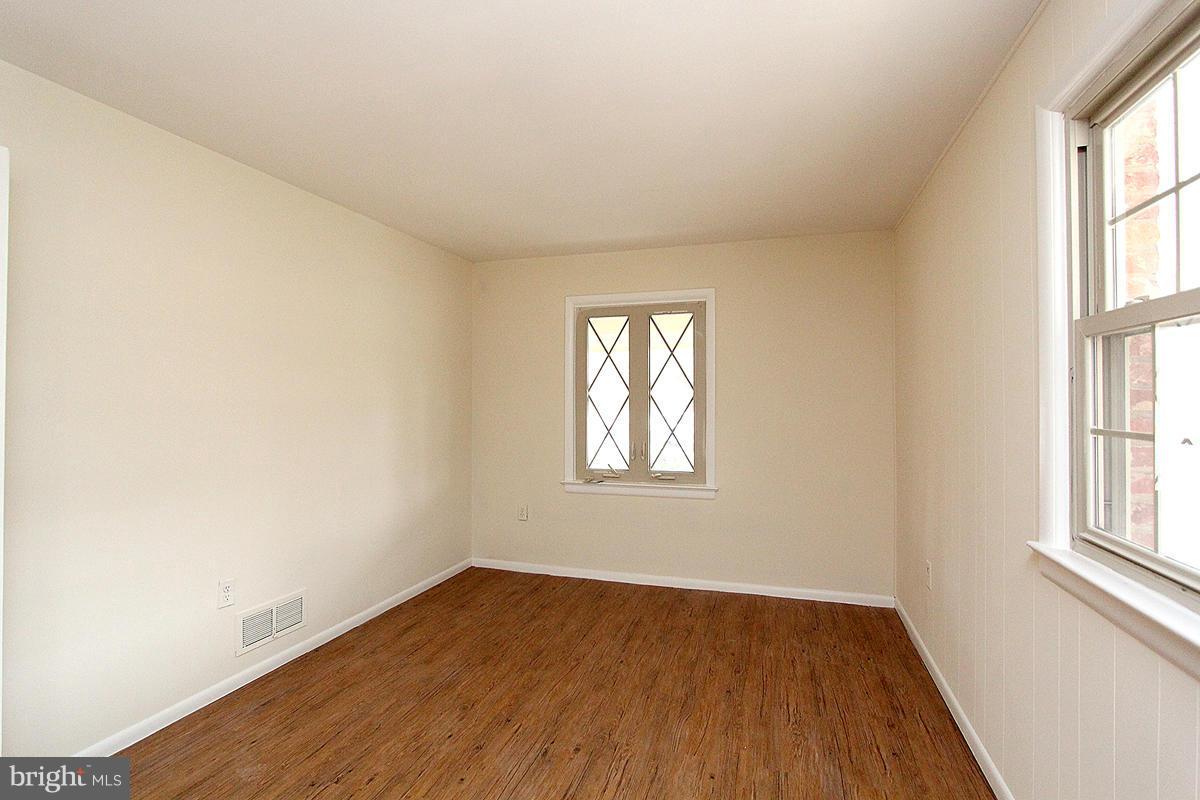 12917 Layhill Road Silver Spring, MD 20906 - Photo 13 of 30 an empty room with wooden floor and windows