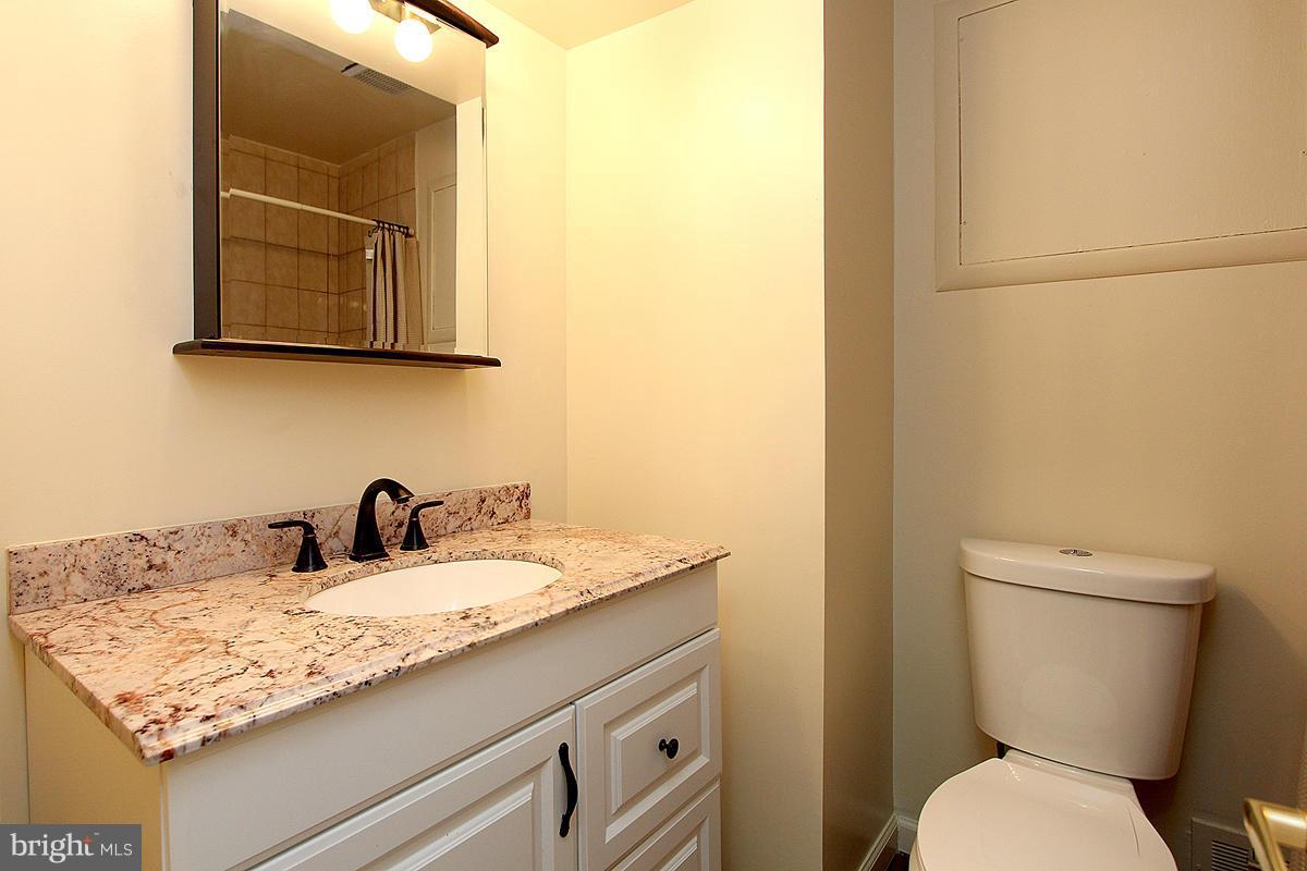 12917 Layhill Road Silver Spring, MD 20906 - Photo 20 of 30 a bathroom with a granite countertop toilet sink and mirror