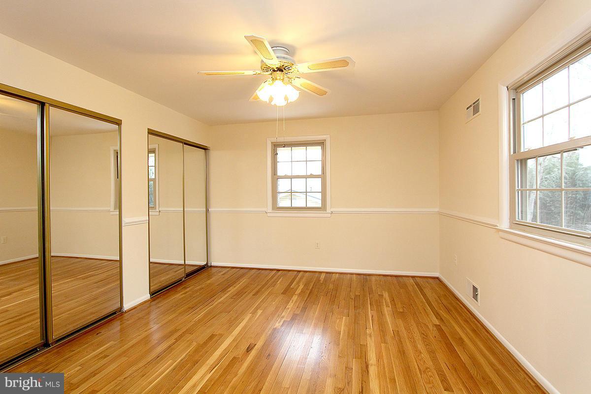 12917 Layhill Road Silver Spring, MD 20906 - Photo 24 of 30 an empty room with wooden floor fan and windows