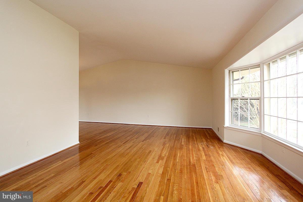 12917 Layhill Road Silver Spring, MD 20906 - Photo 5 of 30 an empty room with wooden floor and windows