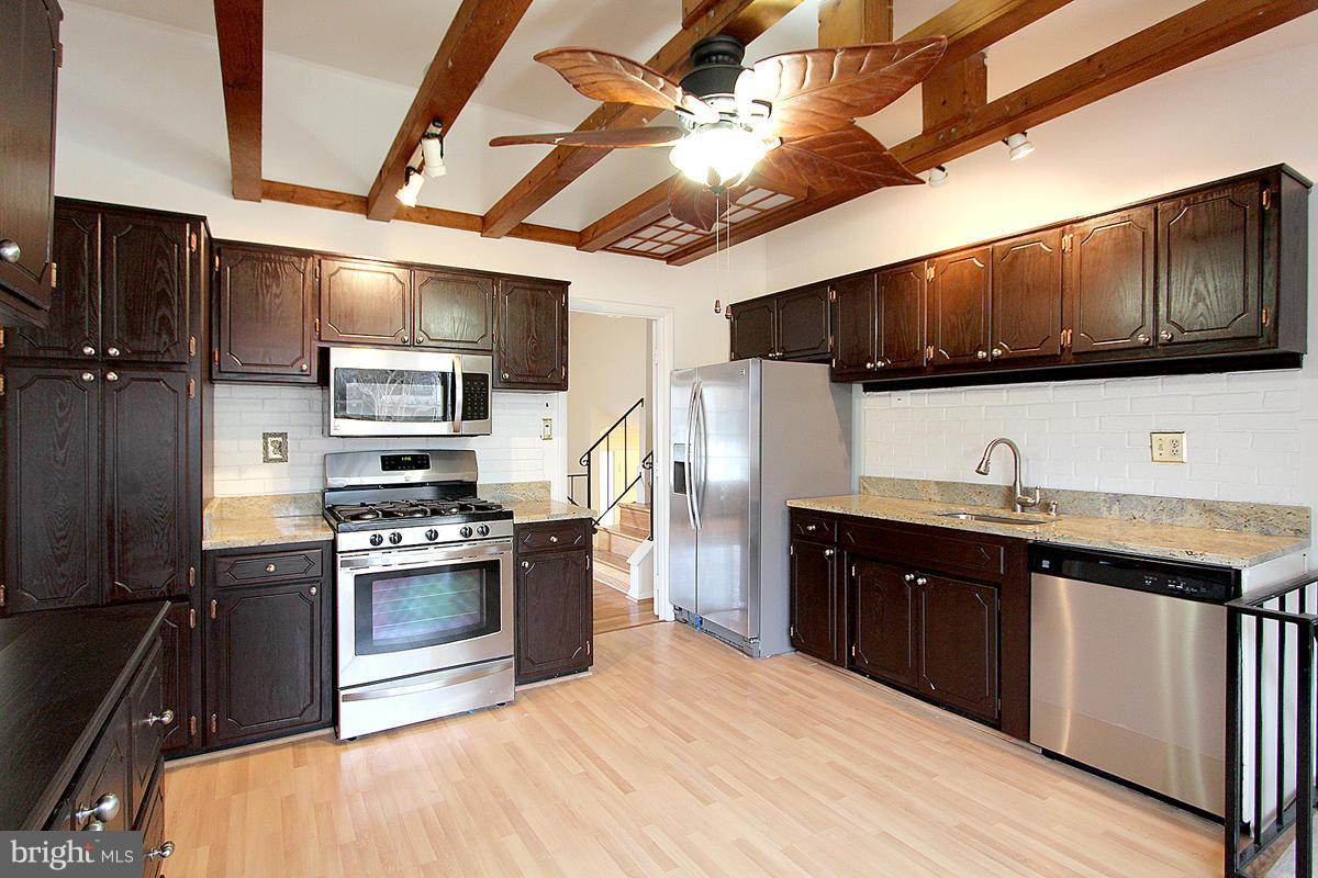 12917 Layhill Road Silver Spring, MD 20906 - Photo 10 of 30 a kitchen with stainless steel appliances granite countertop a sink a stove and a refrigerator