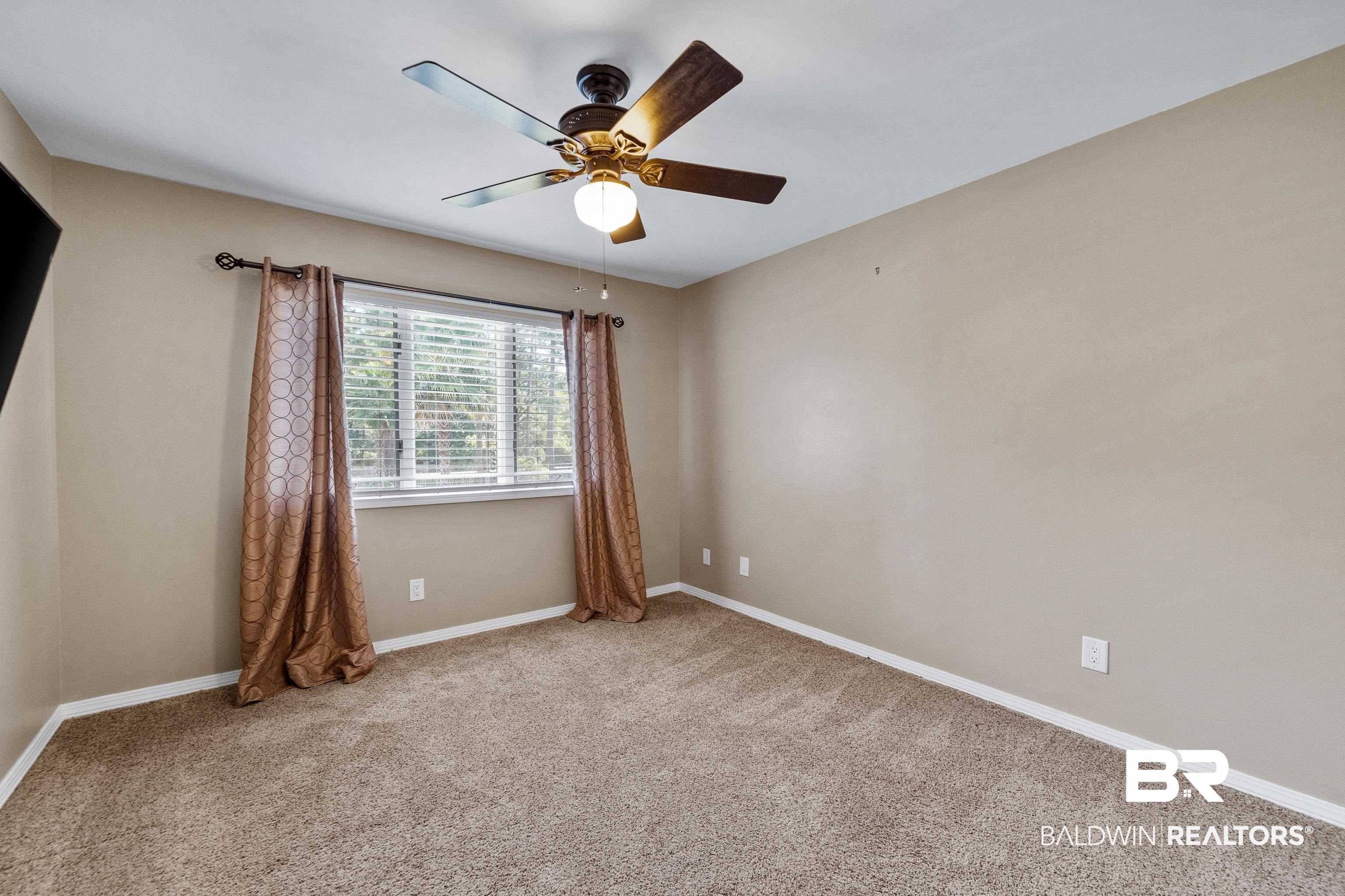 1701 Regency Road, Unit 111 Gulf Shores, AL 36542 - Photo 20 of 29 Empty room with carpet and ceiling fan