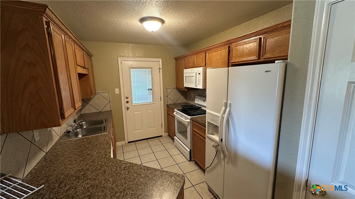 3209 Baldwin Loop, Unit A Killeen, TX 76549 - Photo 5 of 9 a kitchen with refrigerator and window