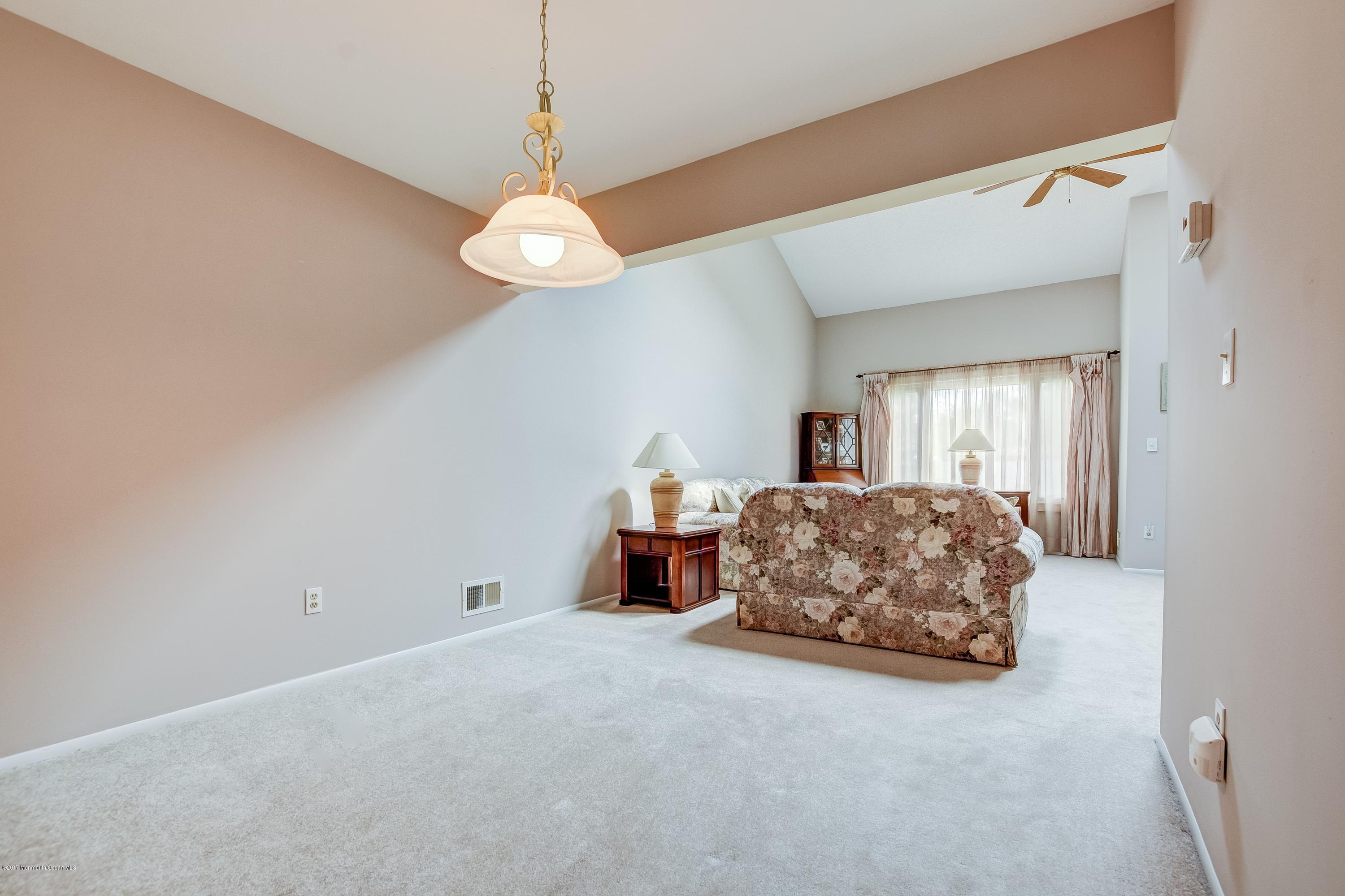 127 Reflection Road Toms River, NJ 08753 - Photo 7 of 20 a living room with a bed furniture chandelier and a window