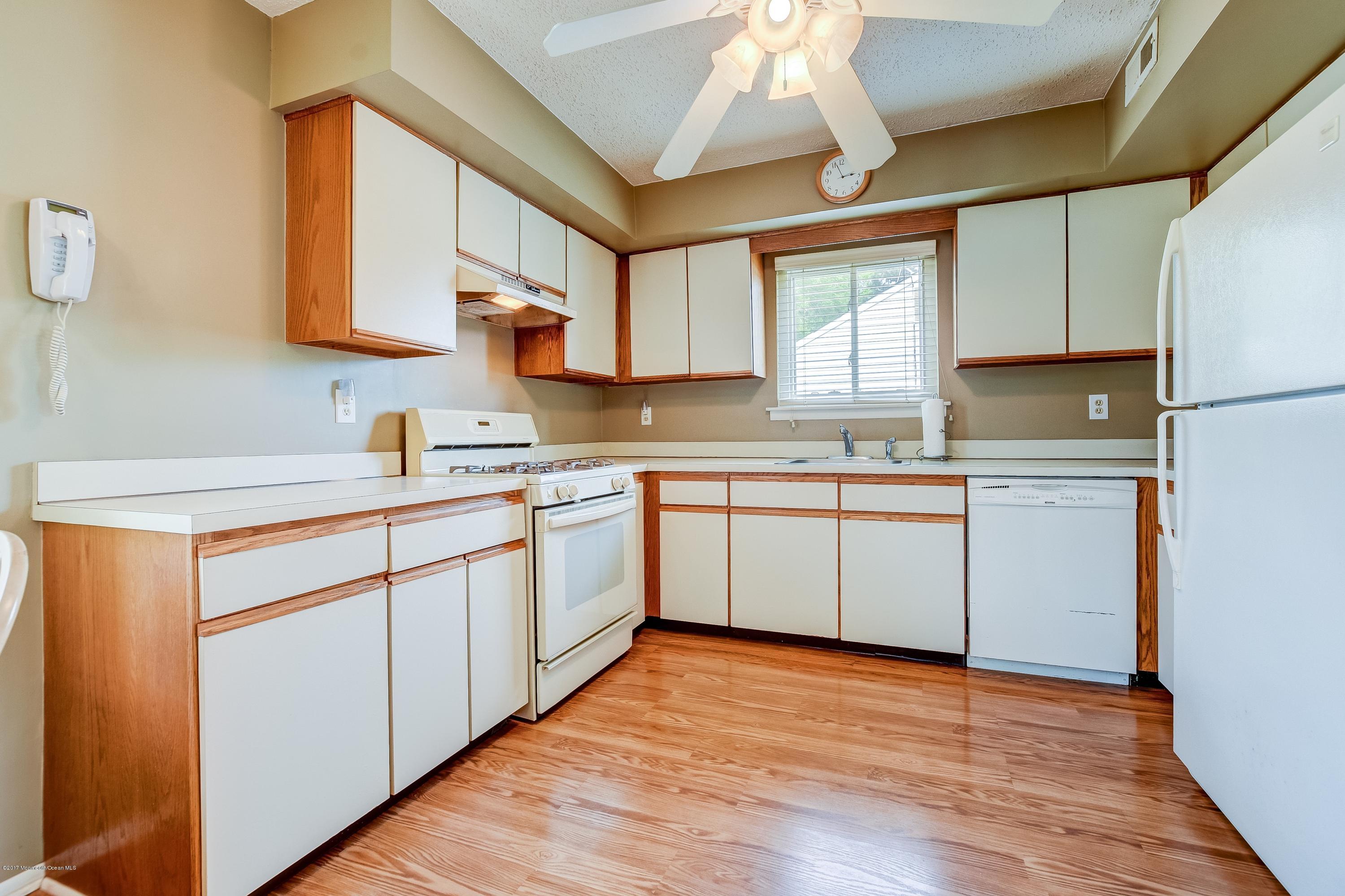 127 Reflection Road Toms River, NJ 08753 - Photo 9 of 20 a kitchen with a white cabinets a sink dishwasher and a stove with wooden floor