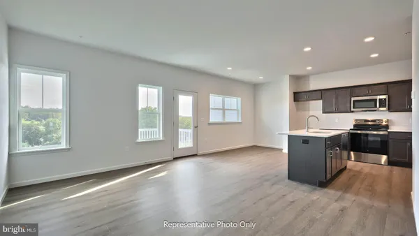 a view of kitchen with stove and cabinets